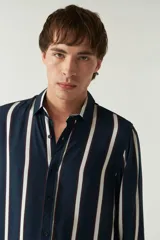 Camisa de mangas largas con estampado a rayas verticales en tonos verde oliva, blanco y azul. Corte regular y logo bordado en el pecho. Confeccionada en viscosa.