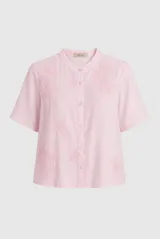 Camisa rosada de manga corta con cuello mao y cierre frontal con botones. Cuenta con sutiles bordados tono sobre tono distribuidos en el frente.