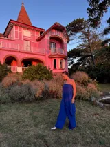 Pantalón de corte amplio y tiro medio, confeccionado en tela crepe color beige, con diseño fluido y holgado.