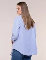 Sobrecamisa holgada de algodón liviano, con estampado de rayas verticales en tonos azul y blanco, diseño oversize, cuello solapa, mangas largas ajustables con presilla y ruedo curvo.