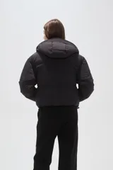 Campera puffer negra con capucha, manga larga, cierre frontal y cuello alto.
