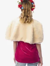 Capa corta de piel sintética en color beige, con diseño reversible que incluye un forro de satén con estampado floral. Presenta un lazo frontal estampado con borlas decoradas con cristales.