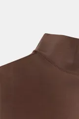 Camiseta sin mangas de corte ajustado con cuello subido, confeccionada en tejido liso de color marrón.