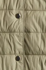 Campera acolchada de nylon con diseño guateado, cuello redondo y cierre frontal mediante botones a presión. Presenta bolsillos laterales discretos, puños con elástico fino y forro interior.