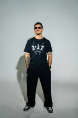 Remera negra de algodón elastizado con estampa frontal en color blanco que incluye el número 3:17, alas y tipografía gótica.
