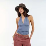 Top gris con cuello halter y escote en V pronunciado. Presenta frunces en el busto y en los laterales, aportando textura y un ajuste ceñido al cuerpo.