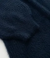 Cardigan abierto de punto pesado con textura peludita, manga larga y diseño alargado. Prenda versátil de corte holgado.