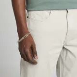 Pantalón chino slim color gris claro, con cinco bolsillos y cierre de botón y cremallera.