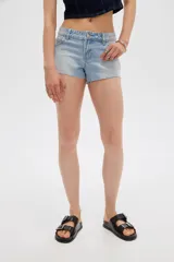 Short de jean tiro bajo y calce ajustado, con dobladillos deshilachados.