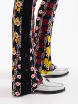 Pantalón de fit recto, confeccionado en viscosa estampada con flores sobre fondo negro. Presenta cintura elastizada y laterales con broches black niquel grabados con logo en la botamanga.