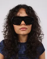 Lentes de sol negros con forma geométrica y protección UV400.