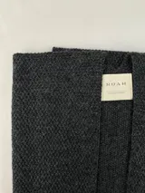 Ruana de punto color gris oscuro, con textura de tejido y diseño holgado.