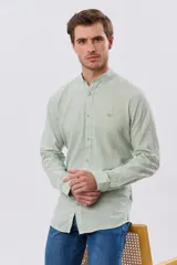 Camisa de lino y algodón color blanco, con cuello mao, manga larga y cierre frontal de botones. Presenta un pequeño logo bordado en el pecho.