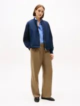 Campera bomber azul marino acolchada con cuello de béisbol, cierre frontal con cremallera, dos bolsillos laterales ribeteados en diagonal y puños y cuello de punto canalé.