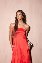 Vestido largo azul con escote strapless, corte suelto y fluido, confeccionado en tafeta con efecto tornasolado, y bolsillos ocultos en los laterales.