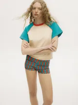 Microshort de lycra con estampado geométrico en tonos beige, negro y rojo.