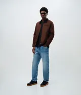Campera masculina modelo trucker confeccionada en sarga de algodón. Presenta cuello de terciopelo en contraste, cierre frontal con cremallera, manga larga y bolsillo con cremallera en el pecho.