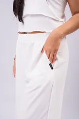 Pantalón palazzo negro de corte wide leg, confeccionado en tela ligera con caída y cintura elastizada de tiro medio-alto.