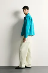 Cazadora relaxed fit de denim de algodón color turquesa, con cuello solapa, manga larga con puño abotonado, bolsillos frontales con solapa y cierre de botones metálicos.