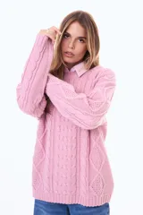 Buzo tejido de punto con diseño de trenzas, color negro, de corte holgado, cuello redondo y mangas largas.