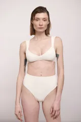 Conjunto de bikini color crema con textura acanalada, compuesto por un top de breteles anchos y una bombacha de tiro alto.