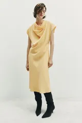 Vestido midi de corte evasé confeccionado en mezcla de modal, con cuello fluido tipo drapeado, manga sisa caída y abertura en la espalda.