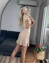 Vestido corto rojo con escote cruzado, mangas cortas y falda con volados. Se ajusta con lazo lateral tipo pareo.