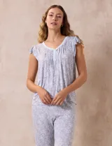 Conjunto de pijama marca René Rofé, compuesto por una remera de escote en V con botones y un pantalón capri con cintura elastizada, ambos en tejido soft estampado con motivos florales en tonos celeste y blanco.