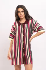 Vestido camisola de tejido de punto fresco con rayas verticales en tonos fucsia, verde oscuro, beige y rosado. Presenta cuello polo marrón, mangas cortas y cierre frontal con botones de madera.