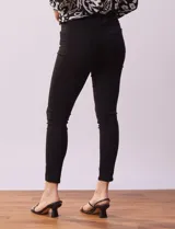 Jean skinny de tiro alto, color azul oscuro, con pretina con pasadores, botón y cierre.