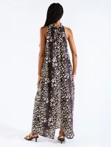 Vestido largo halter con estampado de animal print, en color negro, confeccionado en tejido liviano con hombros descubiertos.