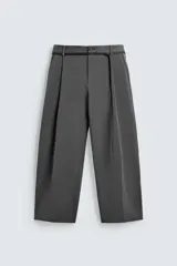 Pantalón de corte balloon fit en color gris, confeccionado en tejido con viscosa. Presenta pliegues frontales, cintura con cinturón integrado a contraste, bolsillos laterales y bolsillos traseros de vivo.