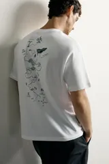 Remera blanca de corte regular fit, con cuello redondo y mangas cortas. Presenta un estampado frontal con textura en tono tostado con la inscripción "Tahoe Lake 1940-1971 Camp Sply."
