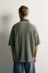 Camiseta relaxed fit de color verde militar, con cuello redondo y mangas ranglán cortas.
