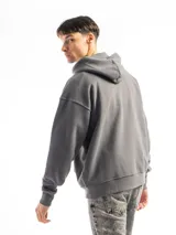 Buzo canguro negro con capucha, bolsillo frontal y corte oversized. Confeccionado en felpa de algodón y poliéster, con rib en puños y ruedo.