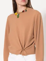 Sweater negro de lana merino con detalle de aro metálico en el frente que frunce la prenda.