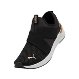 Championes Puma Softride Harli de color negro, con diseño slip-on sin cordones, tiras elásticas cruzadas en el empeine, detalles en tono dorado rosado con la marca en el lateral y el talón, y suela blanca amortiguada.