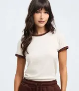 Blusa estilo baby tee de algodón, color crema con cuello y bordes de mangas en color marrón oscuro. Presenta un corte ajustado y diseño minimalista.