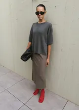 Chaleco de punto gris oscuro, de corte amplio, con escote redondo y mangas cortas.