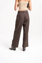 Pantalón sastrero de tiro alto con corte amplio y pinzas frontales. Presenta bolsillos laterales y cierre frontal con botón.