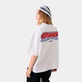 Camiseta blanca de corte cuadrado con estampado en la espalda con el logo de Eme Studios en rojo y azul, y texto en azul.