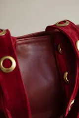 Cartera grande de cuero color marrón con asas de cuero con estampado animal print y ojales dorados.