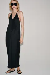 Vestido largo de Zara Woman Collection, confeccionado en tejido satinado negro. Presenta escote en V pronunciado, tirantes finos y un diseño con drapeado fluido en todo el frente.