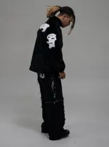 Campera de textura afelpada en color negro, con cuello alto y cierre frontal. Presenta letras bordadas en color blanco en la espalda y en las mangas. Cuenta con ajuste en la cintura y un corte regular.