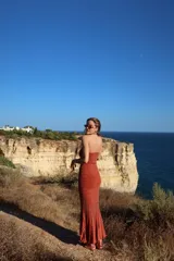 Vestido midi azul de punto con detalles metalizados dorados, escote palabra de honor y corte ajustado al cuerpo.