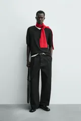 Pantalón de corte balloon fit y estilo relajado, confeccionado en tejido de algodón. Presenta pliegues frontales, cintura con trabillas, cierre frontal con cremallera y botón, bolsillos delanteros y bolsillos traseros de vivo.