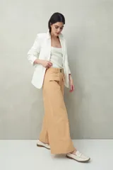 Pantalón wide leg de algodón color negro, de corte amplio y relajado. Presenta bolsillos delanteros con solapa y cierre frontal con botones.