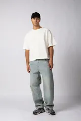 Pantalón de jean con fit balloon, de tiro medio y corte holgado con volumen en la parte superior y caída relajada. Presenta un lavado tipo oxidado que aporta textura y un acabado desgastado.
