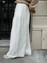 Pantalón sastrero marrón de corte palazzo, con botón, pasacinto y pretina trasera con elástico.