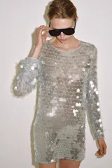 Vestido corto de punto con cuello redondo y manga larga, completamente cubierto de lentejuelas brillantes y perlas decorativas.